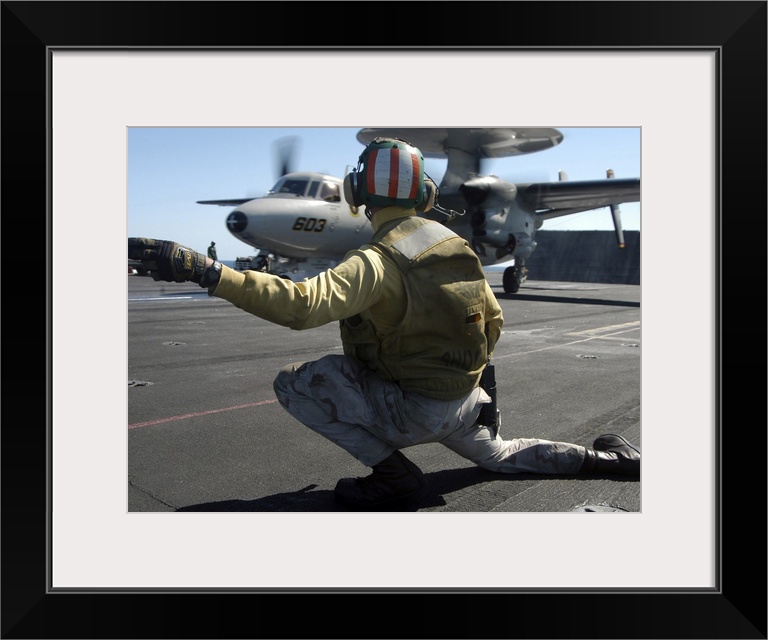 Atlantic Ocean, February 18, 2005 - A catapult shooter signals the launch of an E-2C Hawkeye during flight operations aboa...