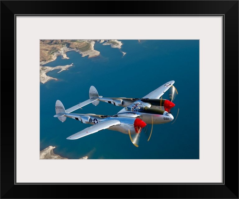 Canvas photo art of a vintage airplane flying above water.