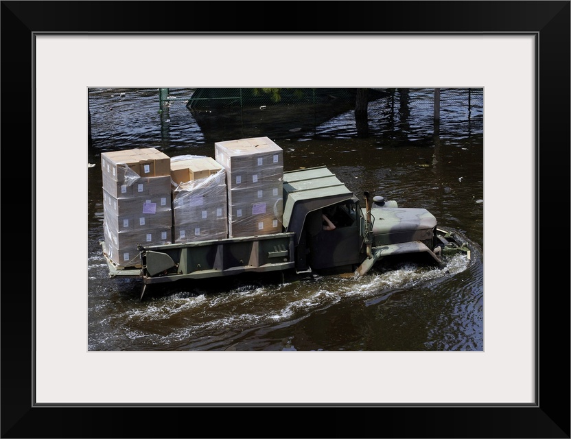 A National Guard M817 5-ton Dump Truck fords the floodwaters left by Hurricane Katrina to take supplies to the Super Dome ...