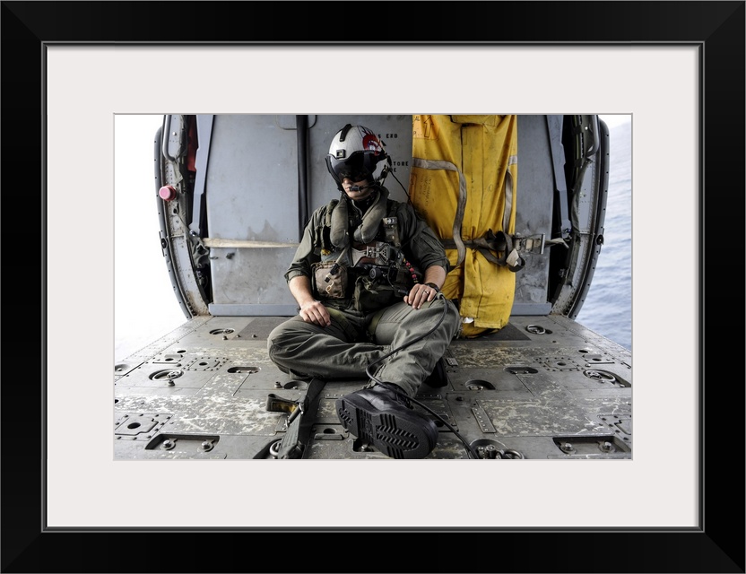 Arabian Sea, August 29, 2013 - A search and rescue swimmer sits in the back of an MH-60S Sea Hawk helicopter.