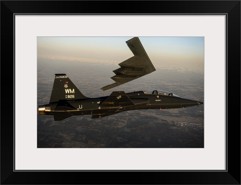 February 20, 2014 - A T-38 Talon flies in formation with the B-2 Spirit of South Carolina during a training mission over W...