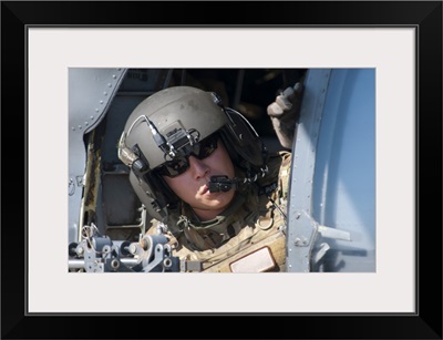 A US Air Force Airman Peers Out The Side Of A HH-60 Pave Hawk