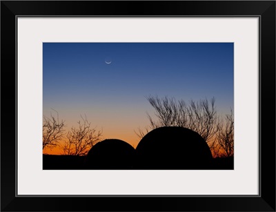 A young moon sets over two domed observatories, Crowell, Texas