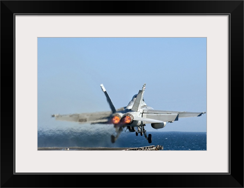 A US Navy F/A-18F Super Hornet launches from the flight deck of aircraft carrier USS Nimitz.