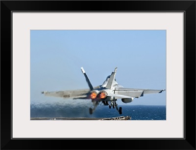 An F/A-18F Super Hornet launches from the flight deck of aircraft carrier USS Nimitz