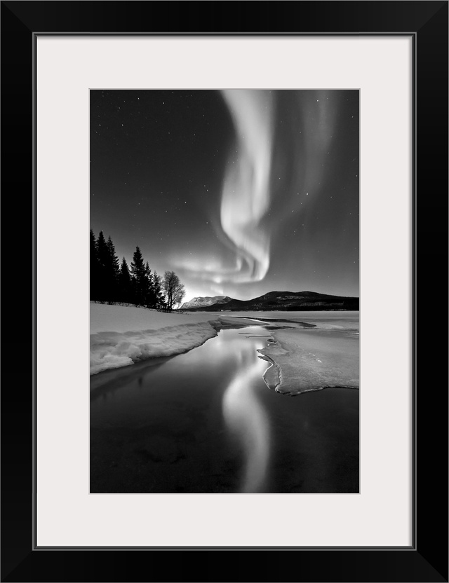 Aurora Borealis over Sandvannet Lake in Troms County, Norway. Auroras are the result of the emissions of photons in the Ea...