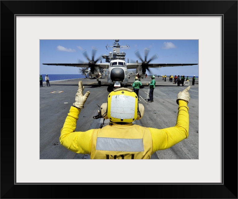 Atlantic Ocean, September 5, 2012 - Aviation Boatswain's Mate directs a C-2A Greyhound onto a catapult on the flight deck ...