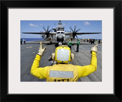 Aviation Boatswain's Mate Directs A C-2A Greyhound Onto A Catapult