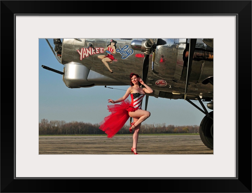 Beautiful 1940's style pin-up girl standing in front of a B-17 bomber.