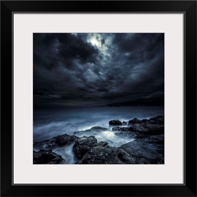 Black rocks protruding through rough seas with stormy clouds, Crete, Greece