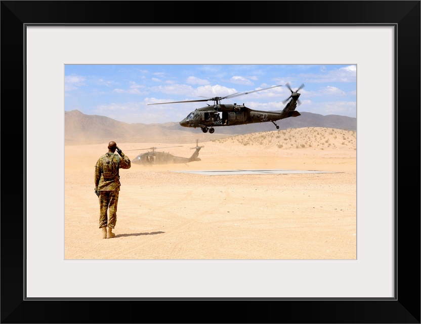 August 4, 2012 - Brigade aviation officer salutes as a UH-60 Black Hawk helicopter lifts off from forward operating base D...