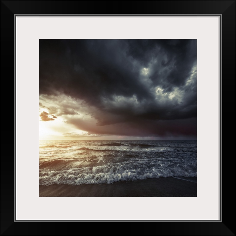 Bright sunset against a wavy sea with stormy clouds, Hersonissos, Crete, Greece.