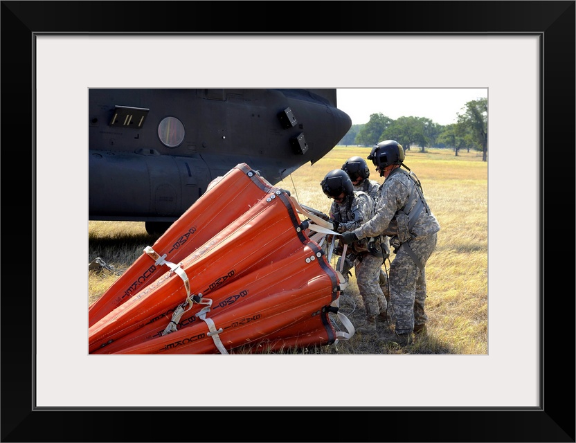 September 6, 2011 - CH-47 Chinook helicopter crew prepare to install the Bambi Bucket on the aircraft. Texas National Guar...