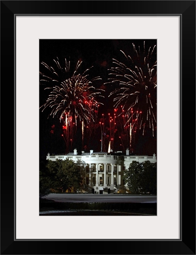 Plumes of firewords explode over top of a lit up White House in Washington, DC.