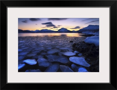 Ice flakes drifting against the sunset in Tjeldsundet strait, Troms County, Norway