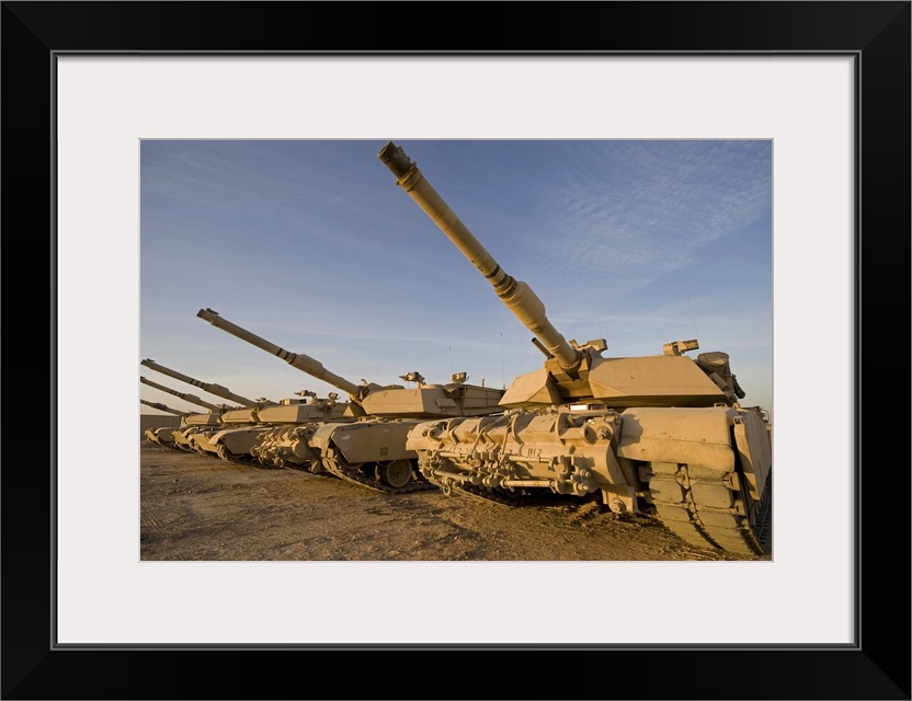 Photograph taken of large military tanks parked in the desert.