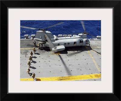 Marines Board A CH-46E Sea Knight Helicopter On The Flight Deck Of USS Peleliu