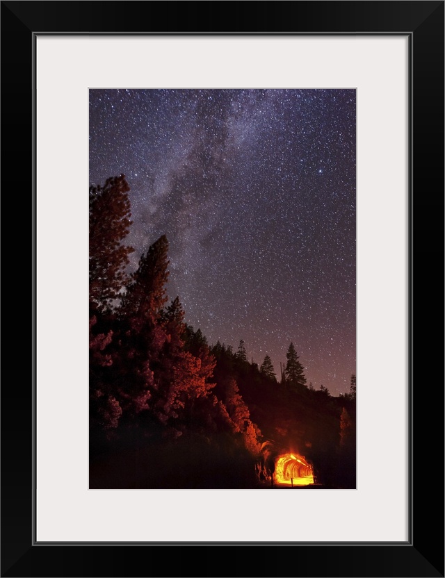 The summer Milky Way rises over the mountain while the tunnel blazes with light in this long exposure photo taken at Yosem...