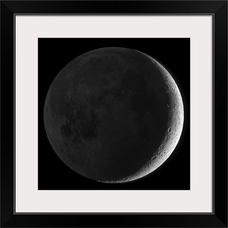 Giant square wall picture of the moon, dark except a small sliver on one side, surrounded by a black background.