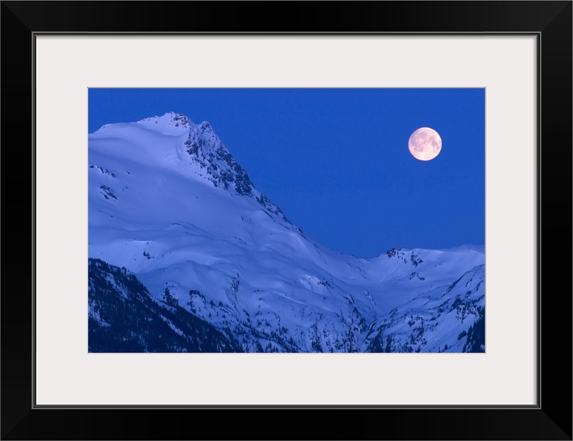 Large image on canvas of a full moon to the right of a tall snowy mountain ridge.