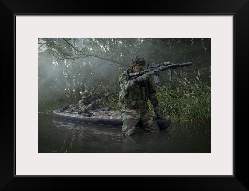 Navy SEALs navigate the waters in a folding kayak during jungle warfare operations.
