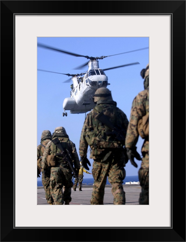 Aboard USS Essex, May 9, 2006 - Personnel walk toward a CH-46E Sea Knight helicopter as they prepare to conduct fast-ropin...