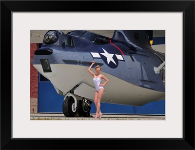 Retro pin-up girl posing with a World War II era PBY Catalina seaplane