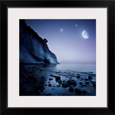 Rising moon over ocean and mountains against starry sky