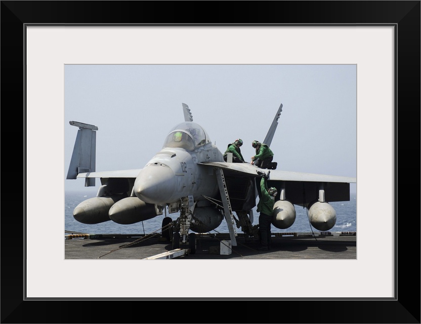 Gulf of Oman, August 22, 2013 - Sailors perform maintenance on an F/A-18F Super Hornet aboard the flight deck of the aircr...