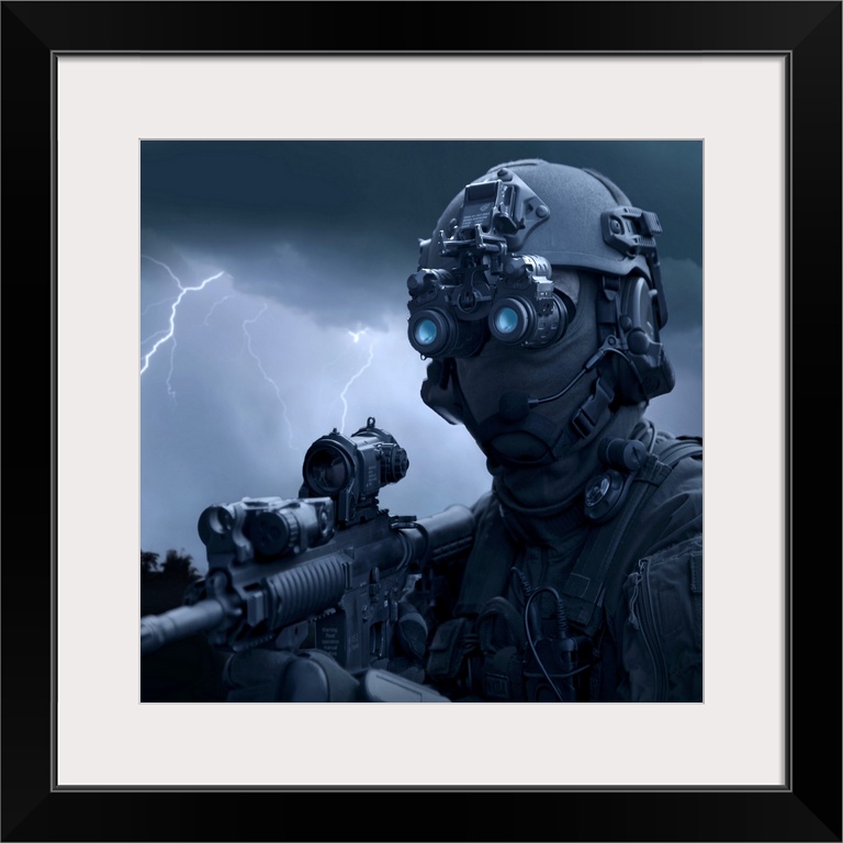 Large horizontal photograph of a special operations soldier holding an HK416 assault rifle and wearing night vision goggle...