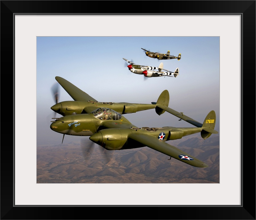 Three vintage military aircrafts are photographed in the sky as they fly high over mountainous terrain in California.