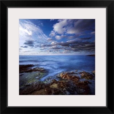 Tranquil lake and rocky shore against cloudy sky, Crete, Greece