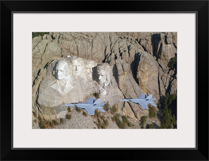 Two military aircrafts are photographed flying by Mount Rushmore.