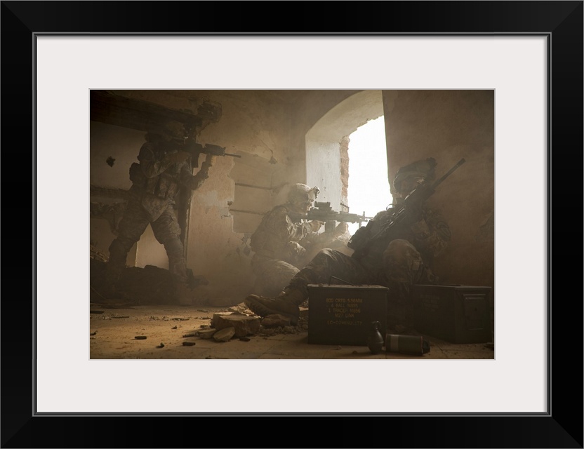 This is a horizontal photograph of three soldiers in a damaged interior peering out a window.