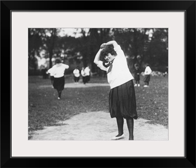 A woman on the pitcher's mound preparing to throw the ball during a softball game