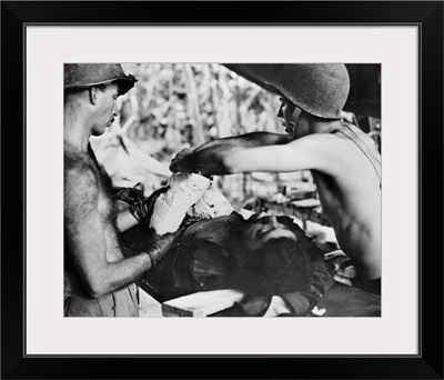Medics operating on a wounded American soldier in New Guinea, 1943