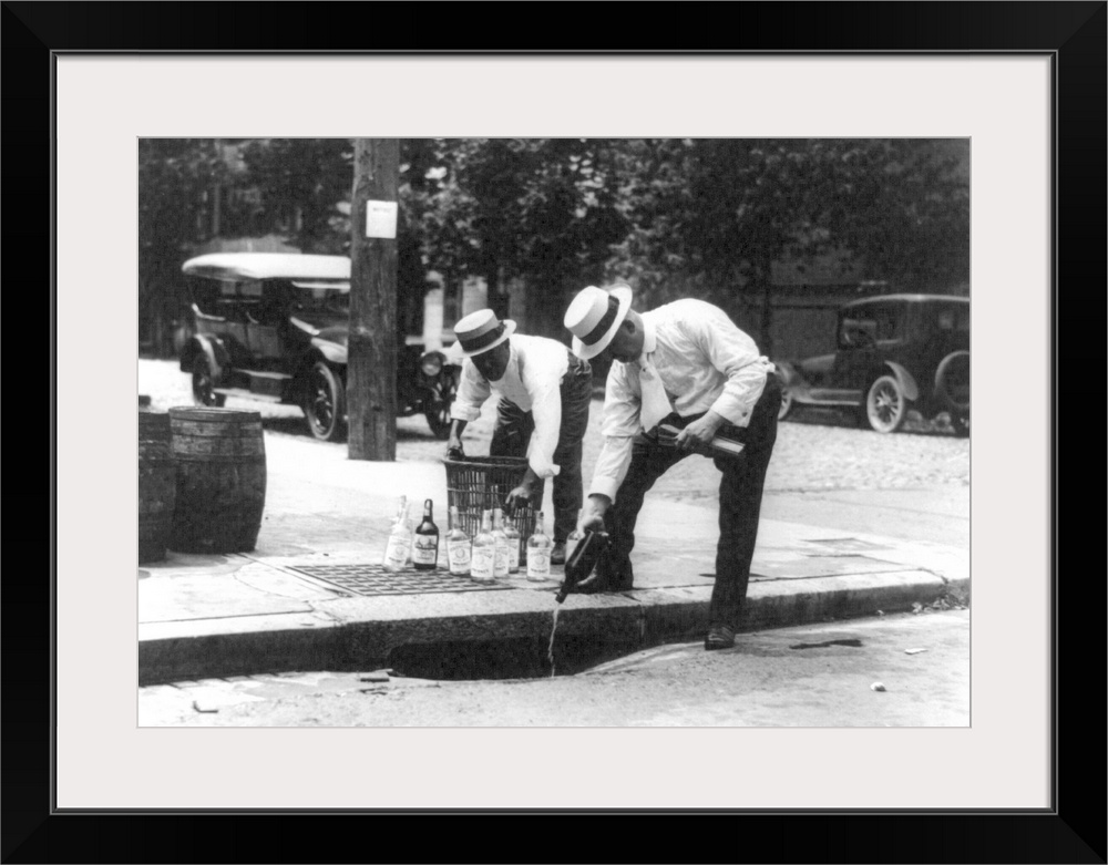 Men pouring bootleg whiskey into a sewer during Prohibition in America, 1920s.