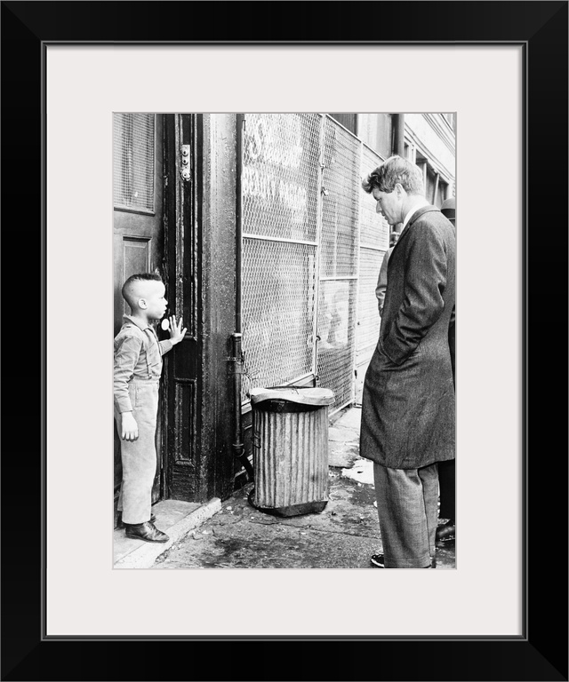 (1925-1968). American lawyer and politician. Senator Kennedy discussing school with a young boy in front of his home on Ga...