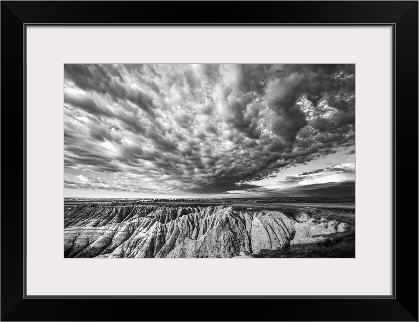 Black and white photo of striking clouds over rock formations in the South Dakota Badlands.