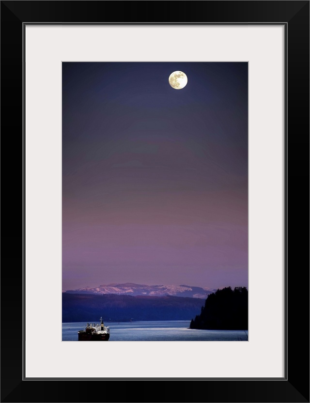 A full moon at night above snow capped mountains and a ship