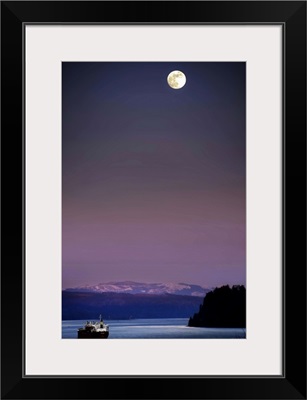 A full moon at night above snow capped mountains and a ship