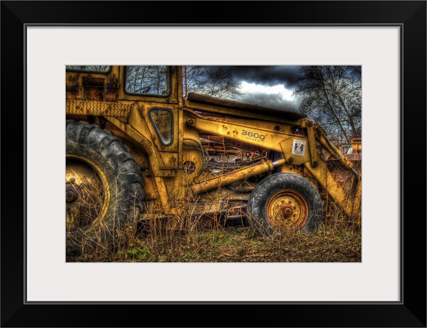 A yellow rusty digger in a field