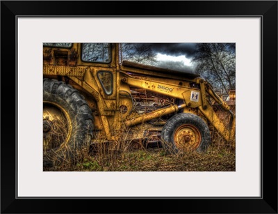 A yellow rusty digger in a field