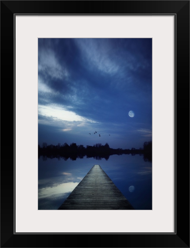 Night scene of a lake seen from a jetty with the moon shining and some birds flying over