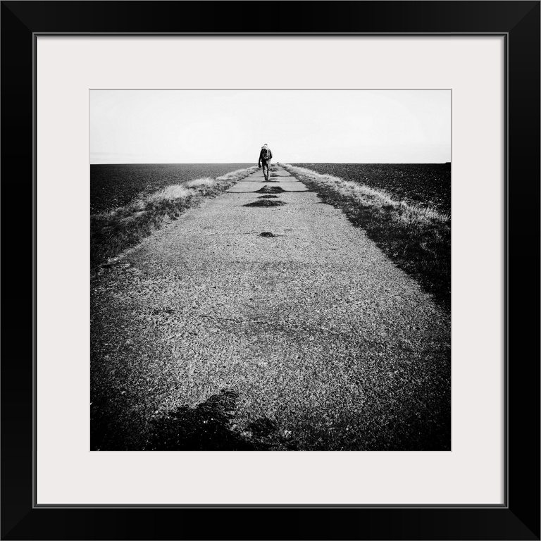 Lone figure on road, hiking with backpack