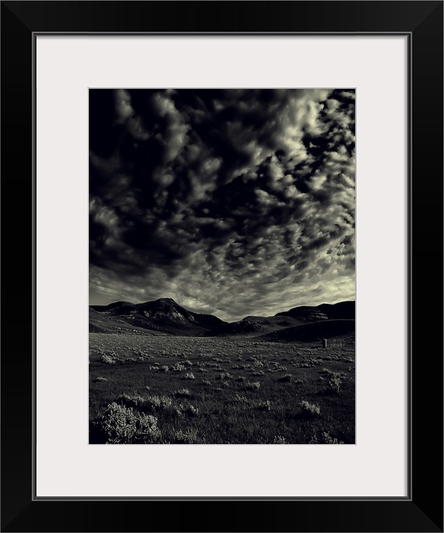 Passing stormclouds over a field, black and white.