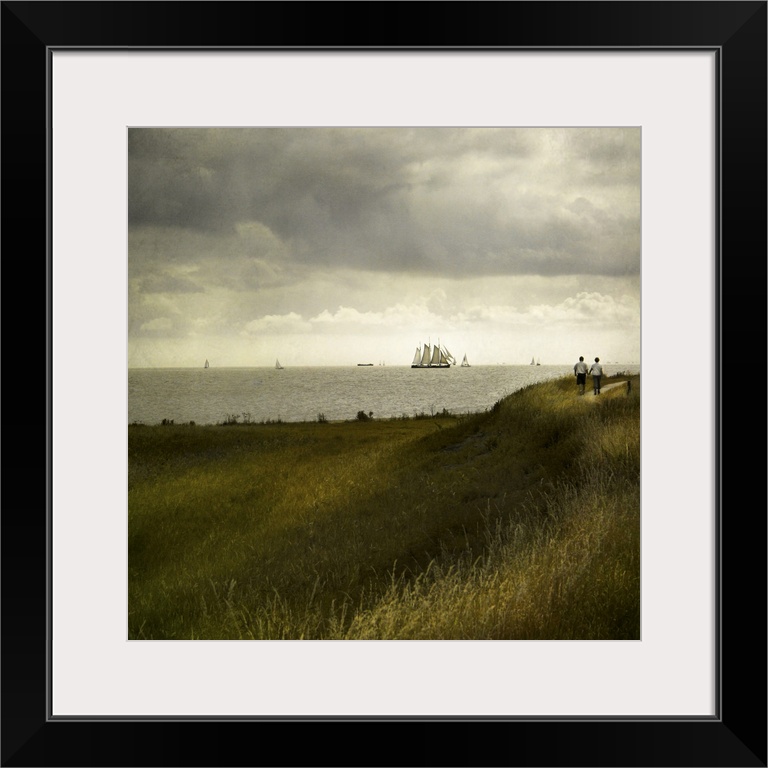 Man and woman walking along a path by the sea with tall ships