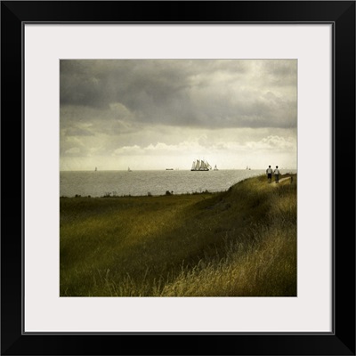 Man and woman walking along a path by the sea with tall ships