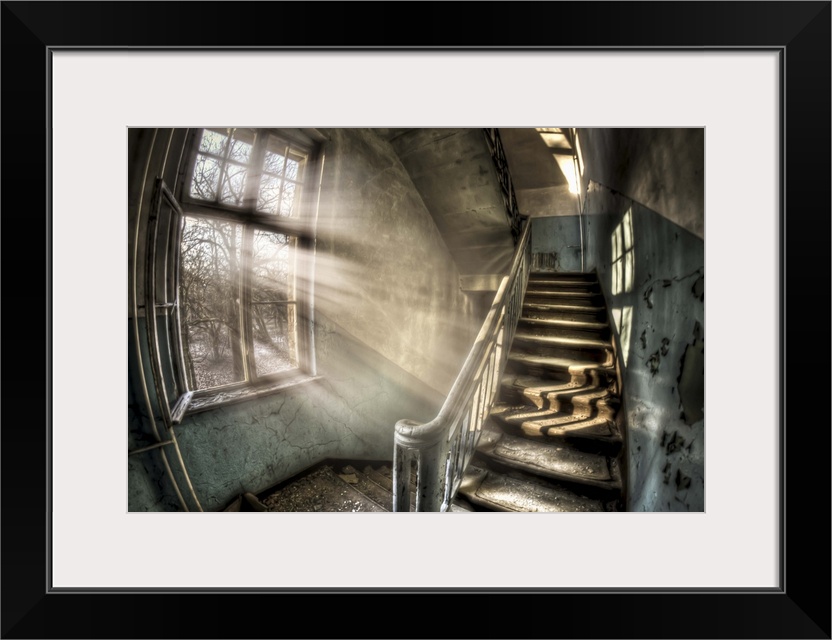 Abandoned lunatic asylum north of Berlin, Germany. Stairwell with sunlight in window.