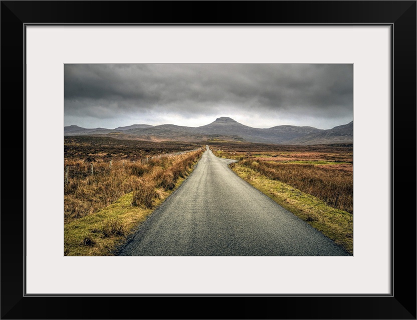 Long straight road towards distant hills in Scotland, UK.